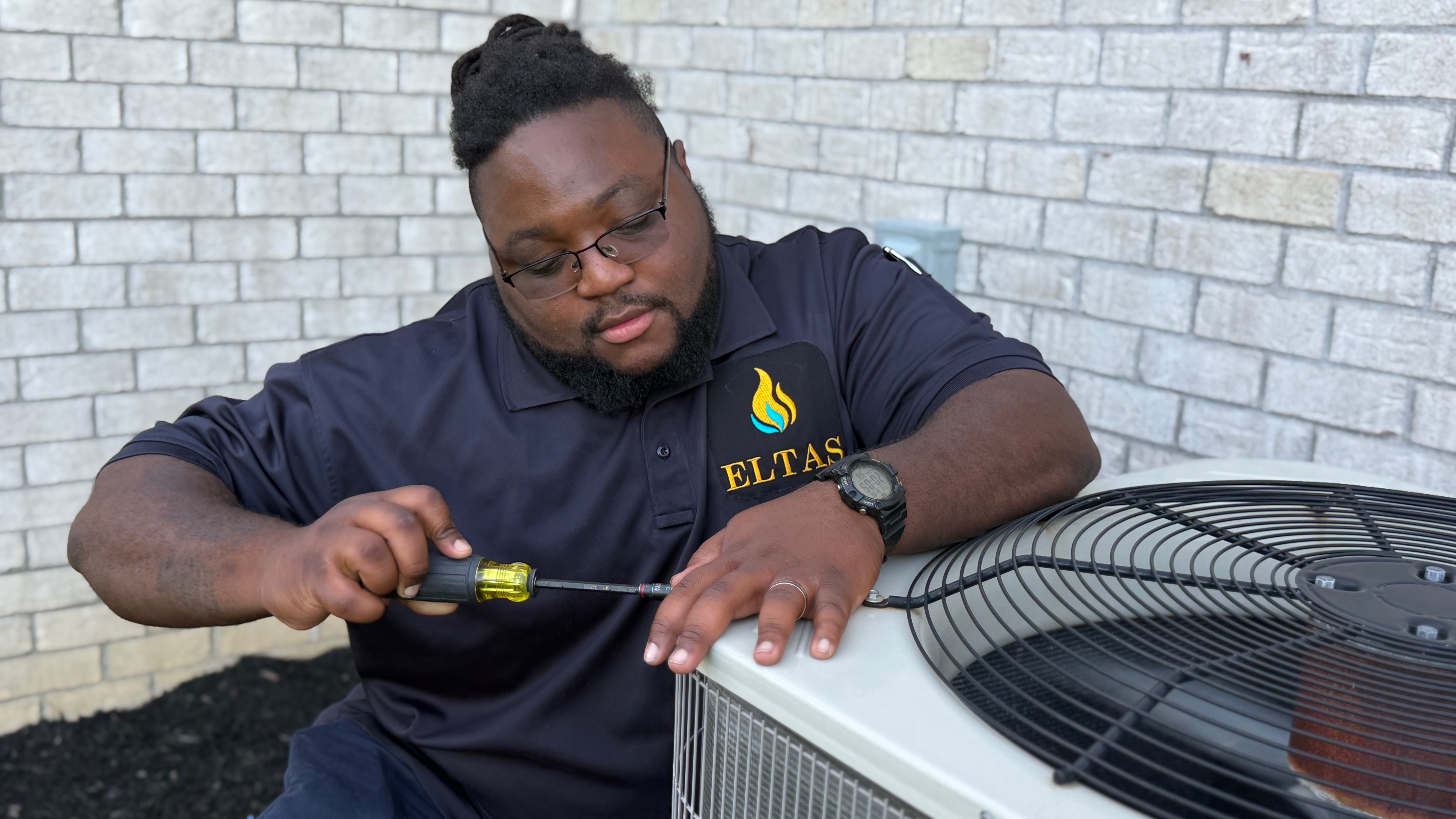 HVAC technician repairing an air conditioner